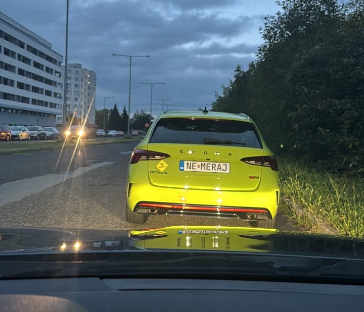 Zelené auto Škoda Octavia s poznávacou značkou „NEMERAJ“ zaparkované na kraji cesty počas súmraku.