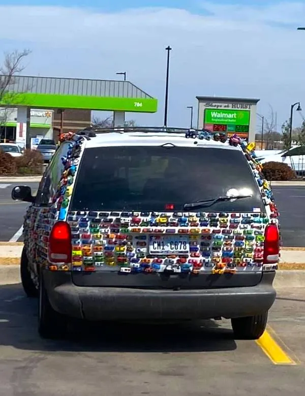 Auto pokryté malými modelmi áut na parkovisku pri obchode Walmart.