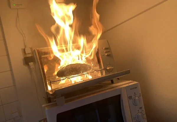 Chlieb horí v rúre na pečenie, spôsobujúc kuchynský požiar. Nezabudnite vždy dohliadať na varenie pre bezpečnosť.