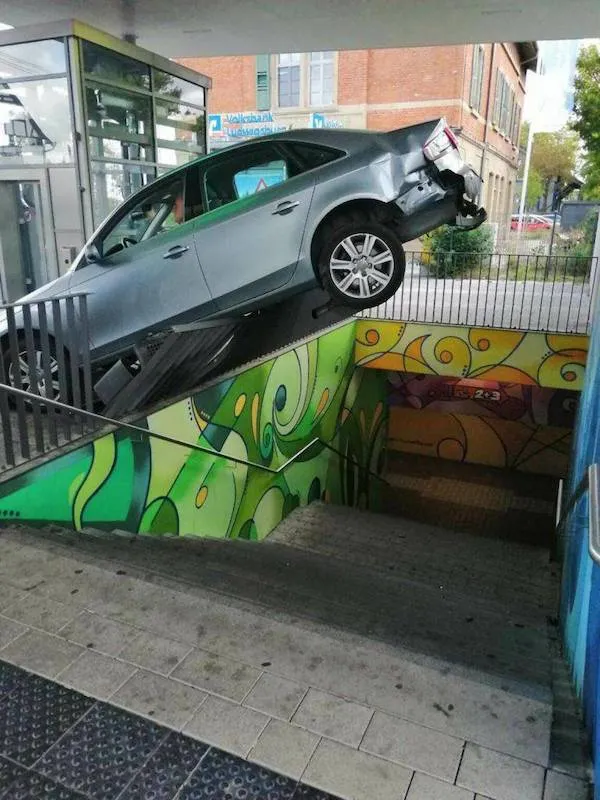 Auto uviaznuté na schodoch vedúcich do podchodu s farebnou stenou.