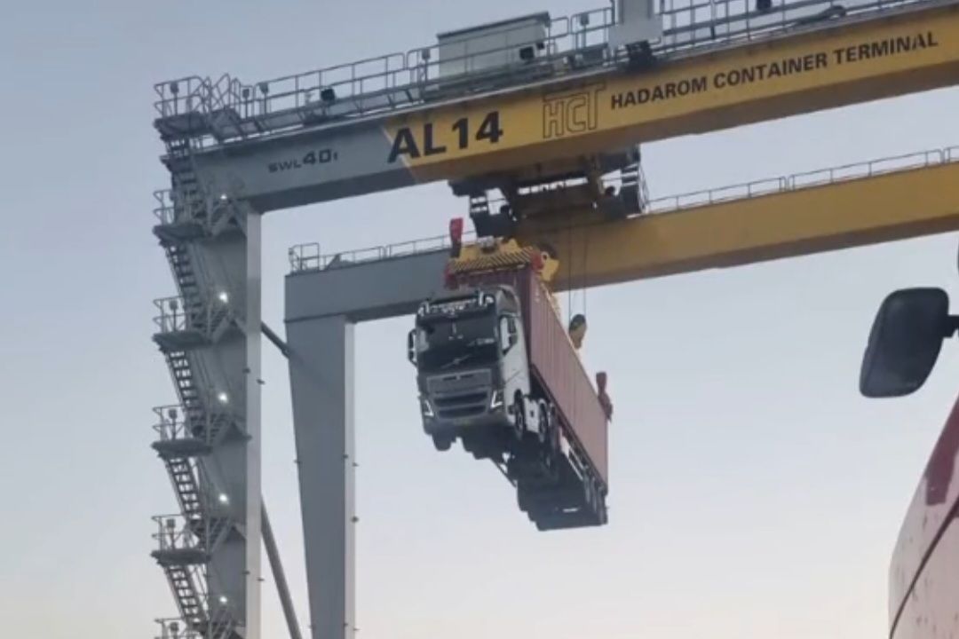 Žeriav zdvíha nákladné auto v kontajnerovom termináli Hadarom.