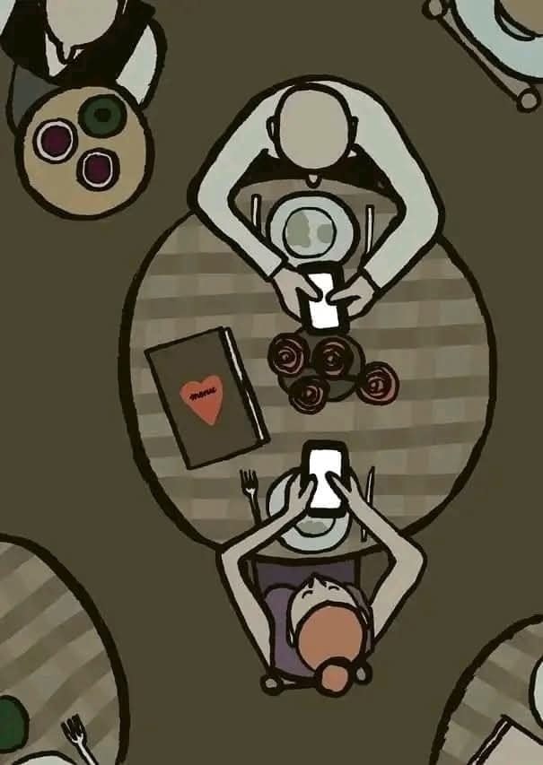 Dvaja ľudia pri stole s knihou a mobilmi, pohľad zhora, symbolizujú modernú komunikáciu.