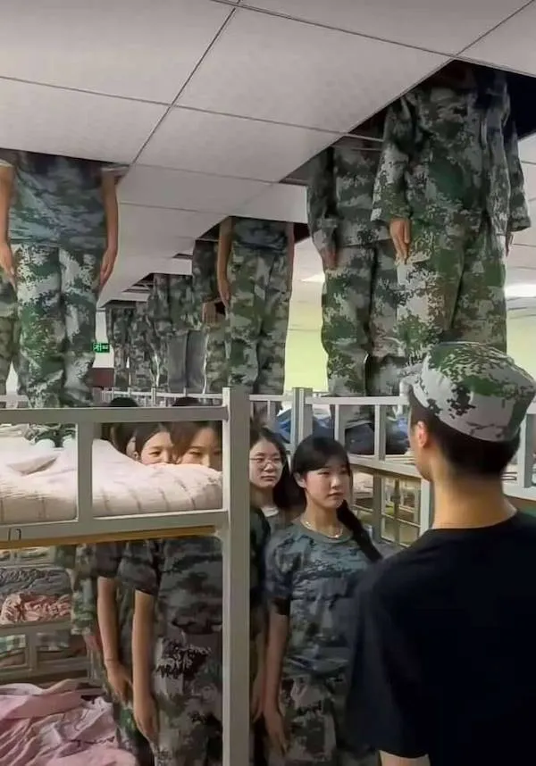 Vojenské cvičenie s vojakmi stojacimi pod stropmi v izbe s poschodovými posteľami.