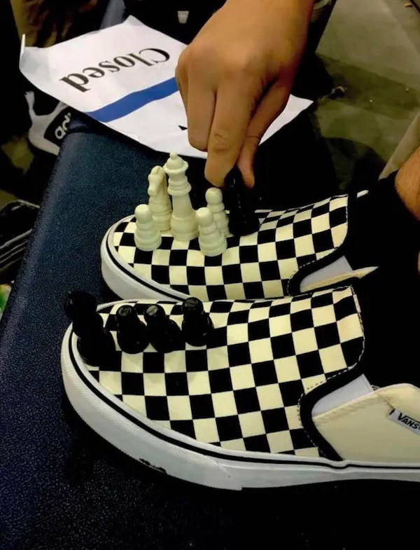 Čiernobiele tenisky s šachovými figúrkami na šachovnicovom vzore, kreativita v obuvi.