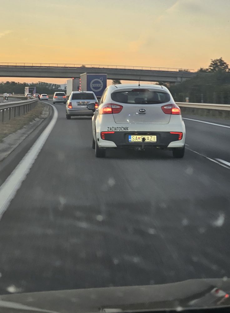 Auto s nálepkou začiatočník na diaľnici za súmraku.