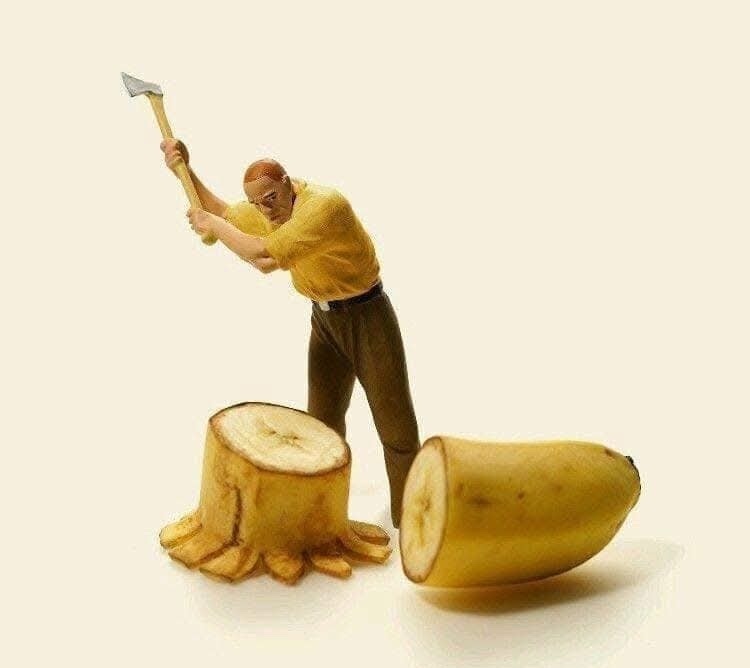 Muž sekerou štiepe banán, paródia na drevorubača s komickým twistom.