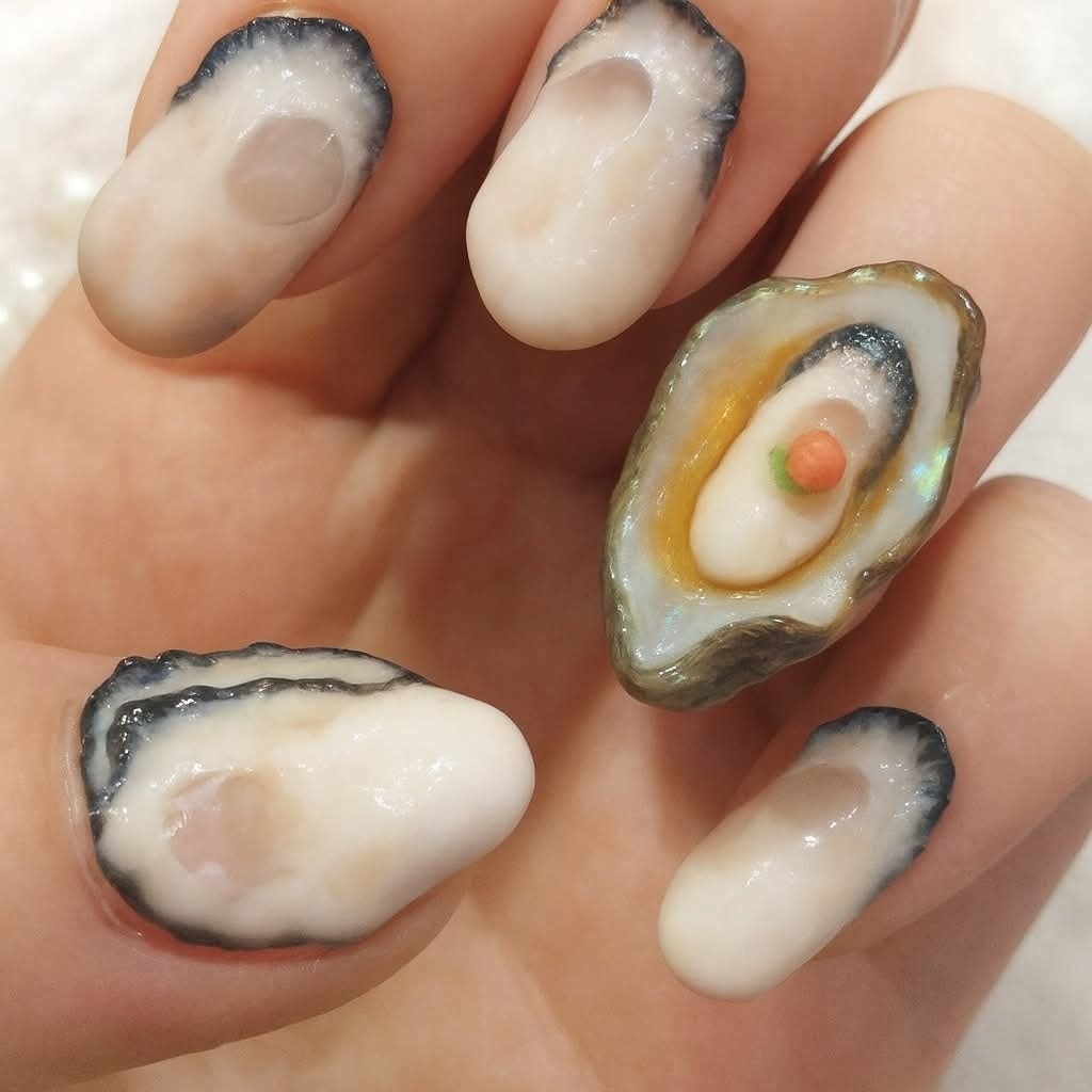 Neobvyklá manikúra s nechtami dizajnovanými ako mušle s perlorodkami. Kreatívny 3D nail art inšpirovaný prírodou.