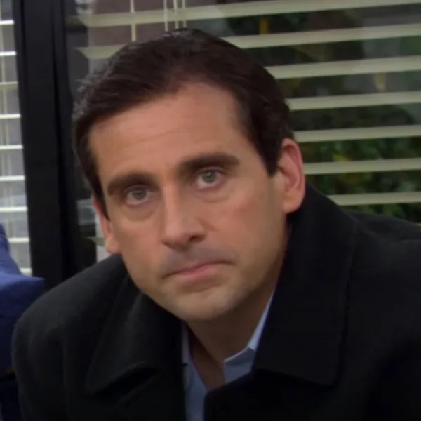 Ložím sorry. Je mi ľúto, ale nemôžem určiť, kto je na obrázku.Skúsim však napísať alternatívny text:„Muž v čiernom saku a košeli s neutrálnym výrazom tváre.“