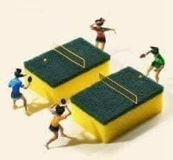 Miniatúrni športovci hrajú stolný tenis na hubkách s pálkami, kreatívna interpretácia hry.