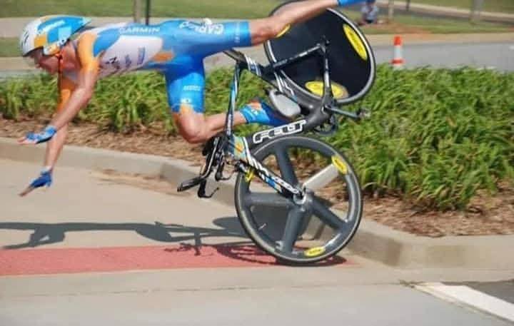 Cyklista padá z bicykla počas jazdy na časovke na pretekoch, koleso vo vzduchu.
