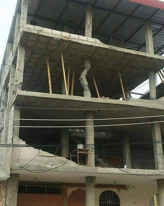 Budova s viditeľnými konštrukčnými nesúladmi a drevenými oporami, naznačujúca riziko zrútenia.