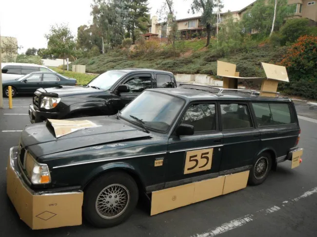 Auto so štartovým číslom 55 so súpravou z kartónu na parkovisku, upravené pre zábavný pretek.