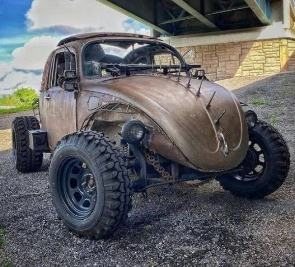 Staré auto s terénnymi kolesami pod mostom, pripravené na dobrodružnú jazdu po nerovných cestách.