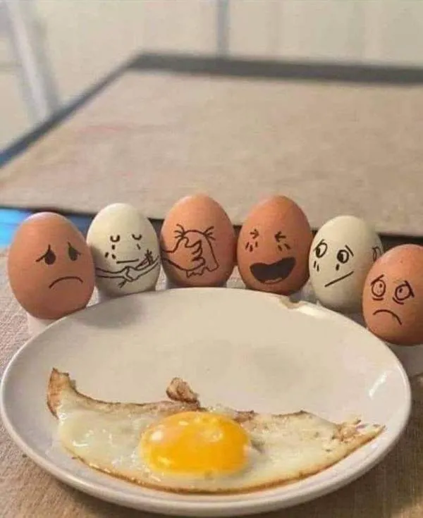 Vajcia s tvárami vyjadrujú rôzne emócie pri pohľade na praženicu na tanieri.