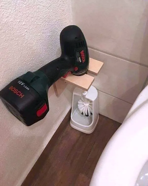 Vtipné použitie vŕtačky ako držiaka na toaletnú kefu v kúpeľni.
