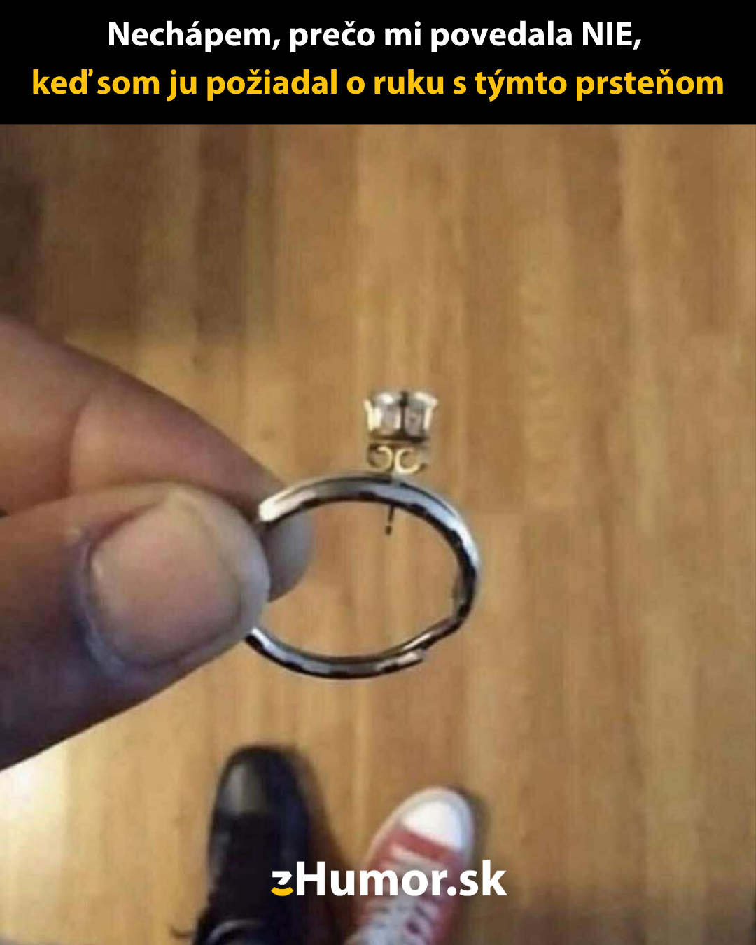 Muž drží uško z plechovky ako improvizovaný zásnubný prsteň zamiestnený k červenej a čiernej topánke.