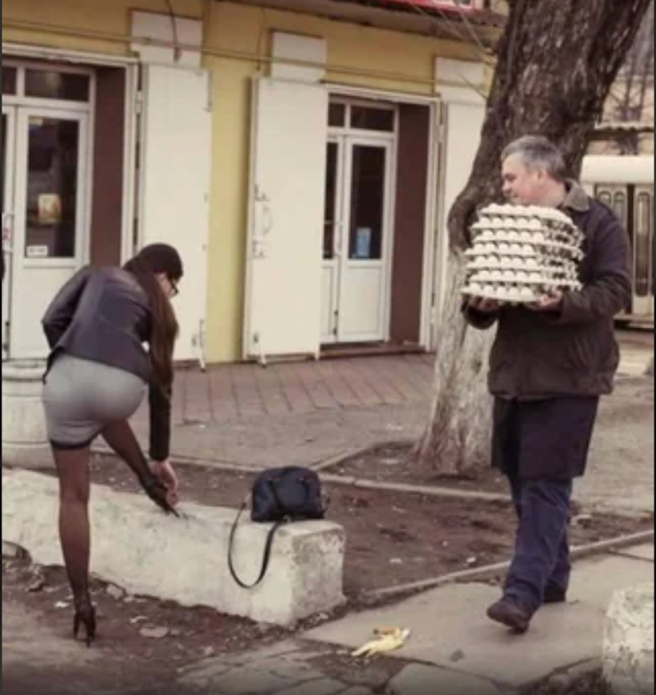 Muž nesúci vajcia a žena opravujúca topánku pri chodníku, vedľa leží banánová šupka.