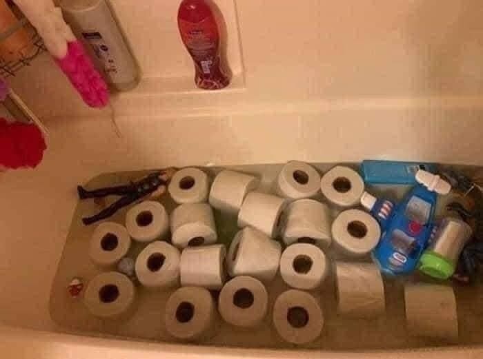 Toaletné papiere plávajúce vo vani plnej vody spolu s hračkou a kozmetikou.