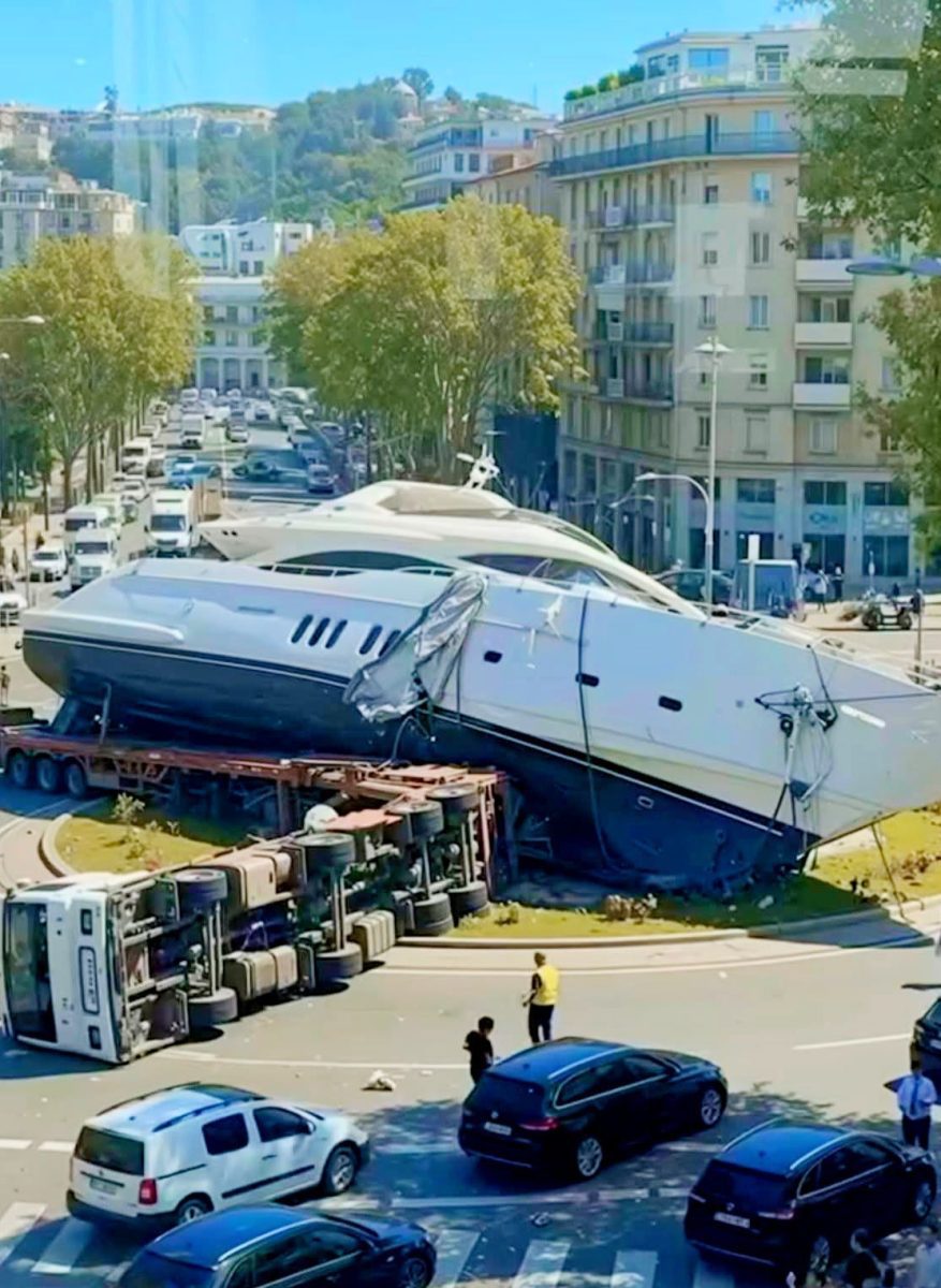 Nehoda s kamiónom prevážajúcim jachtu v centre mesta, ležiaca loď na kruhovom objazde.