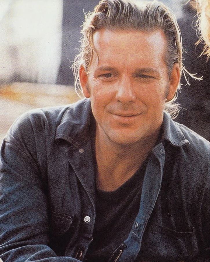 ľutujem, nedokážem určiť totožnosť osoby na obrázku. Ak by ste potrebovali alternatívny text, môžem poskytnúť všeobecný popis:Muž usmievajúci sa v neformálnom oblečení vonku.