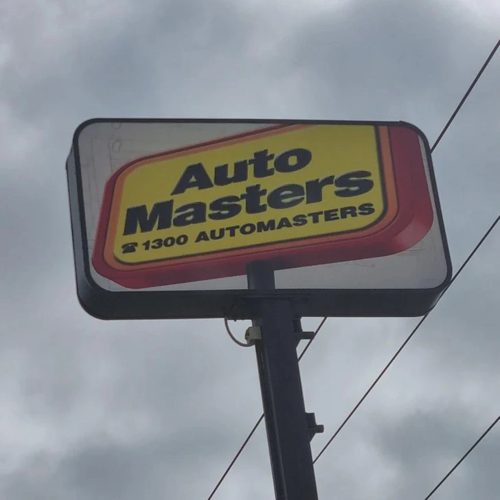 Reklamný stojan Automasters s telefónnym číslom 1300 na oblačnej oblohe.