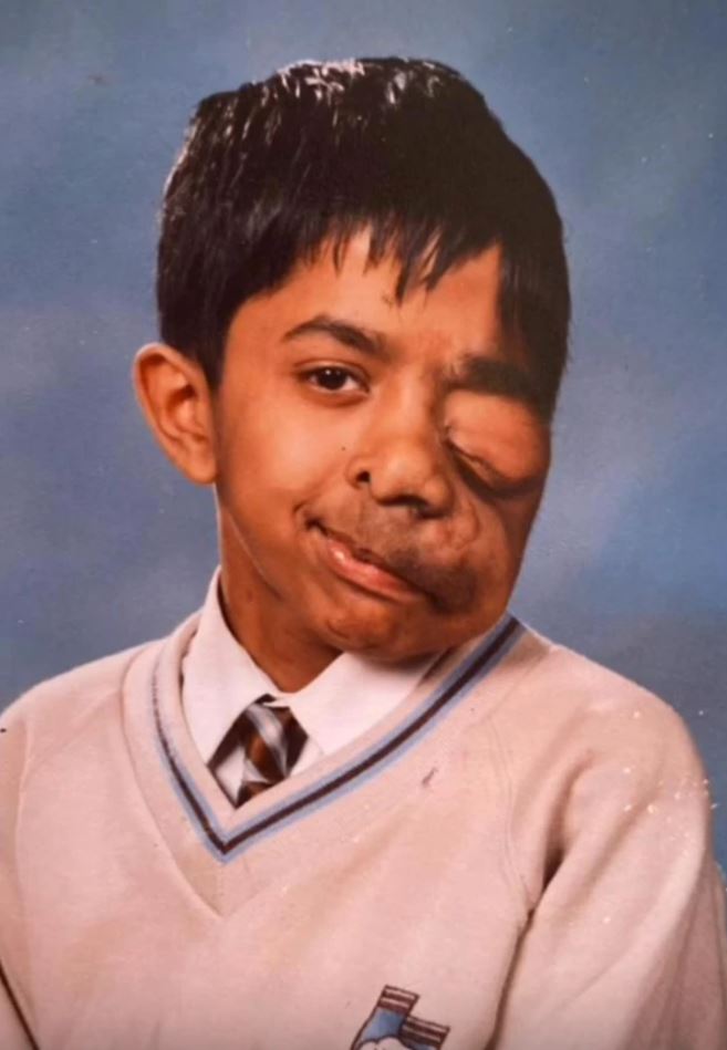 Ložisko chlapca v školskej uniforme s modrou a bielou dekoráciou na pozadí.