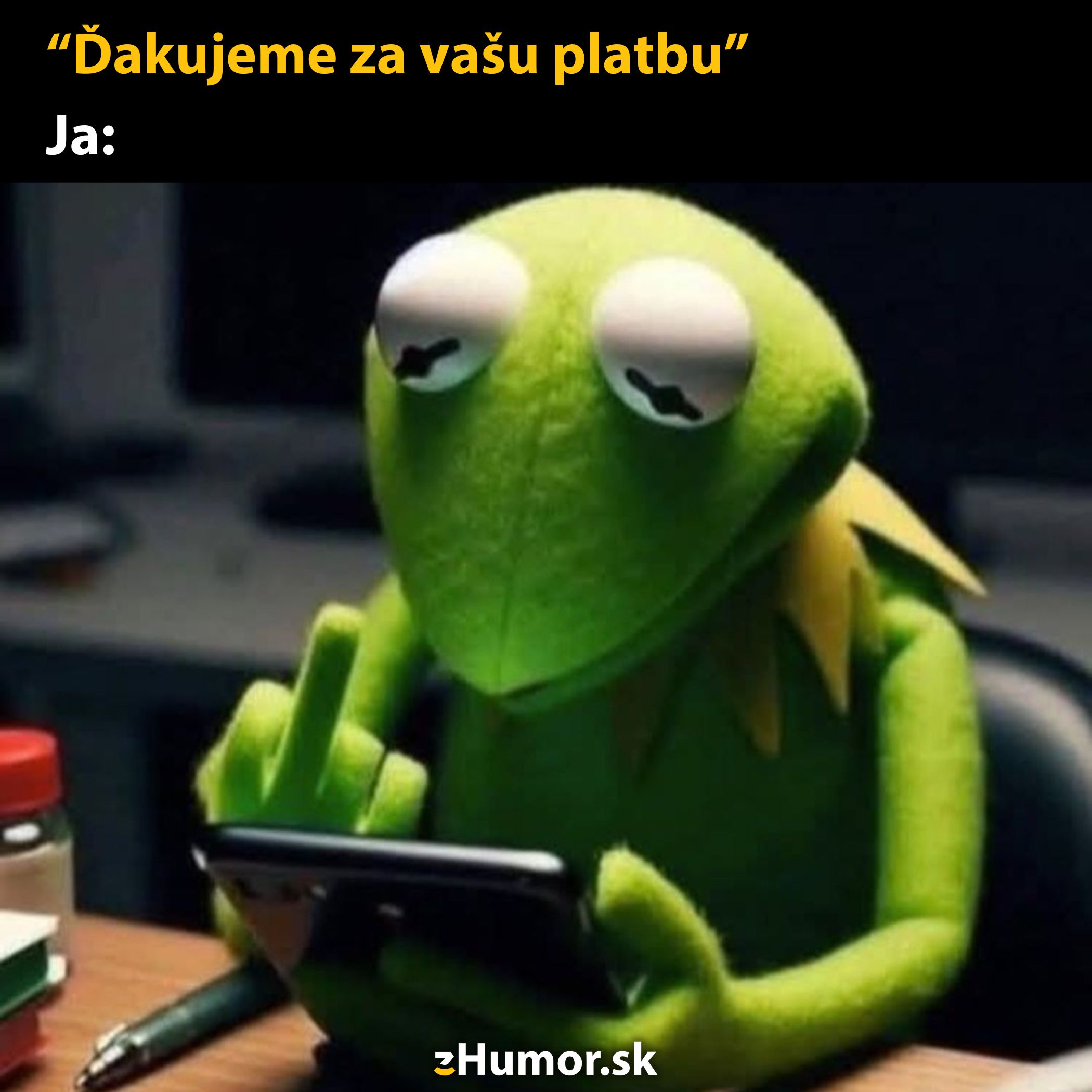 Žaba pri stole ukazuje gesto prostredníkom s mobilom v ruke ako reakcia na platbu.