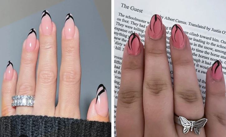 Ružové nechty s čiernymi detailmi, prstene na rukách. Pozadie s knihou a svetrom poskytuje kontrast. Elegantná manikúra.