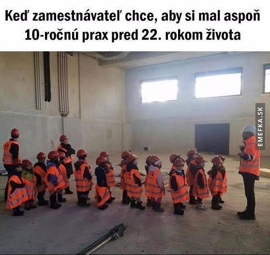 Deti v stavebných vestách a prilbách stoja v rade vo vnútri budovy, ilustrujúc narážku na prax v mladom veku.