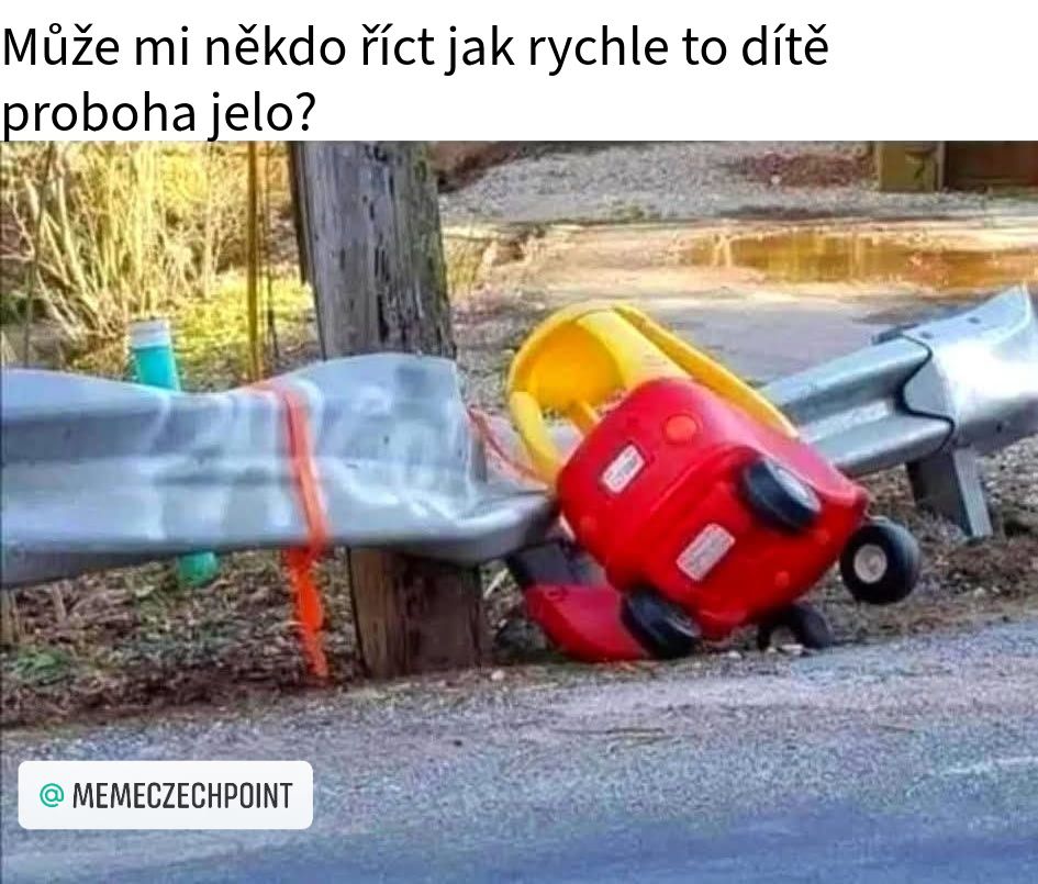 Detské autíčko prevrátené pri zábradlí na ceste, vtipná situácia so zábranou a otázkou o rýchlosti jazdy dieťaťa.