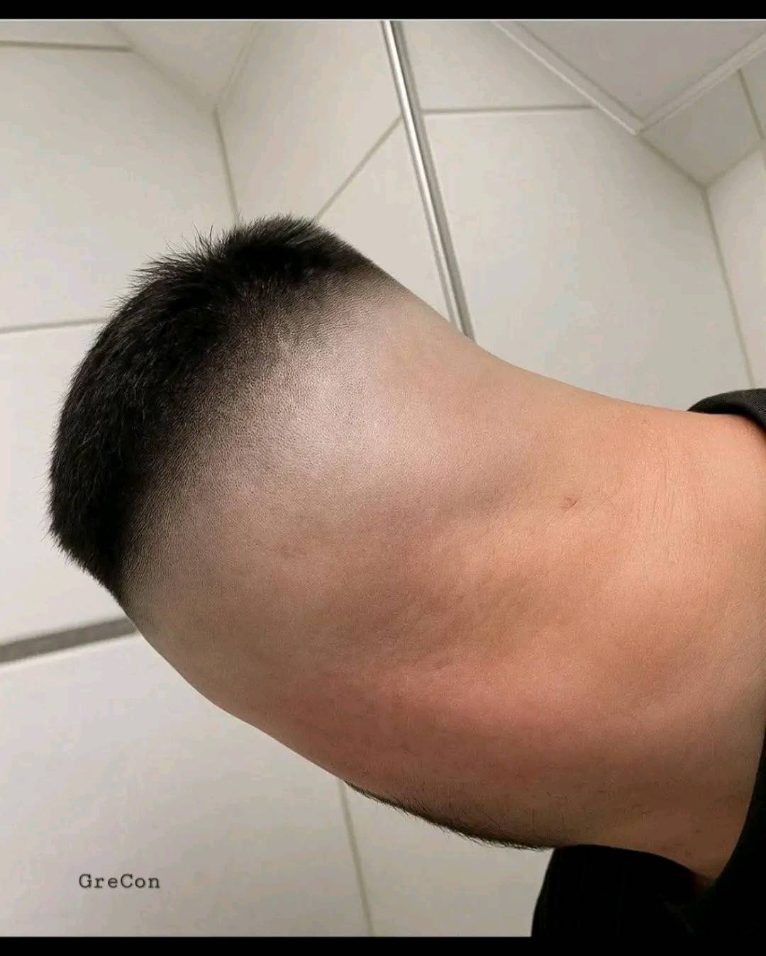 Ľudská hlava otočená smerom dole so zvláštnou ilúziou, pripomína zadnú stranu tela s krátkym účesom.