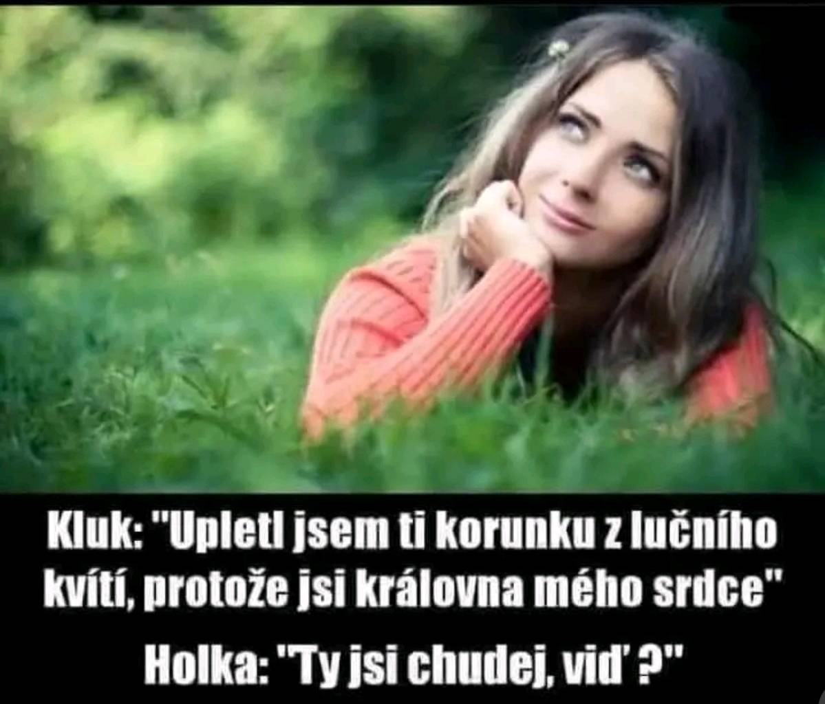 Dívka leží na tráve v parku, sníva a usmieva sa s vtipným textom o romantickom darčeku.