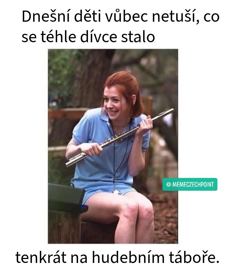 Dívka s flautou v modrom oblečení sedí vonku a usmieva sa na hudobnom tábore.