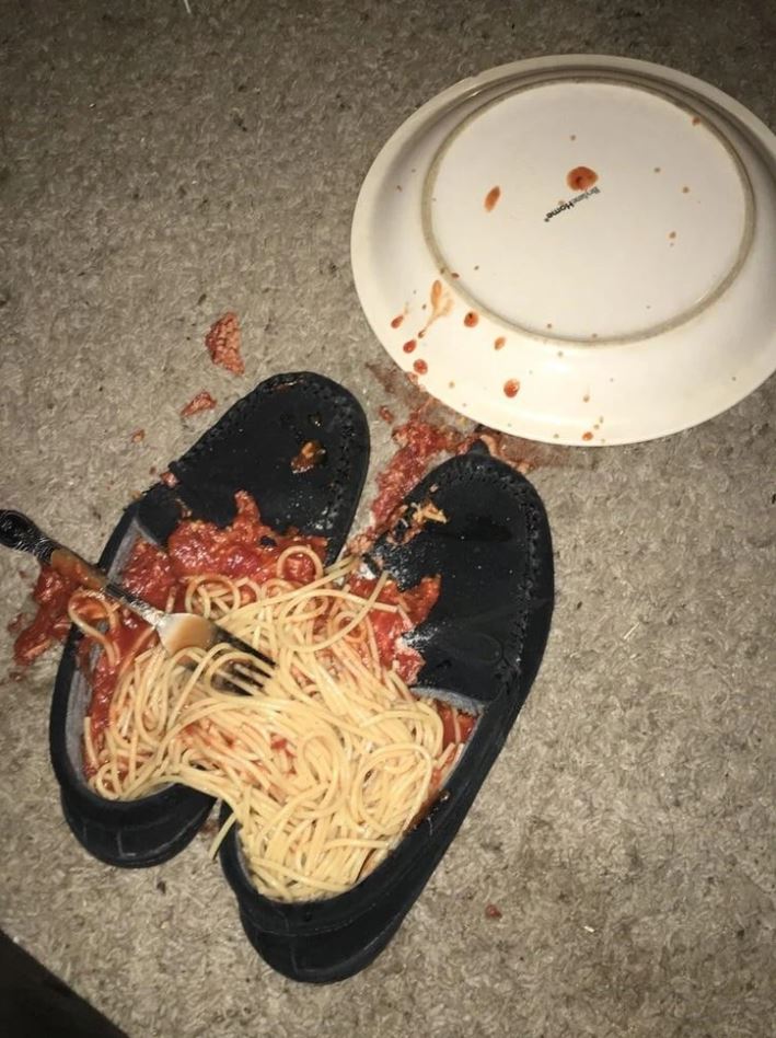 Špagety s rajčinovou omáčkou vysypané na topánky a koberec vedľa prevráteného taniera.