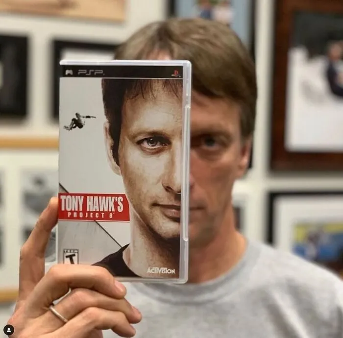 Osoba držiaca obal videohry Tony Hawk's Project 8 pred svojou tvárou.
