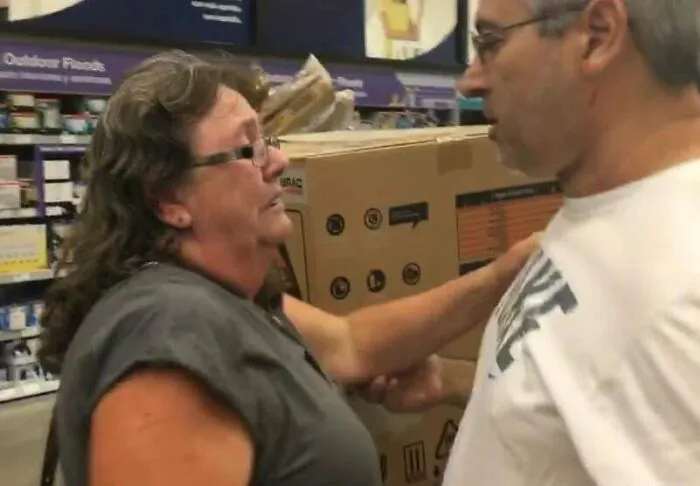 Ľudia debatujú v obchode pred krabicou s domácimi spotrebičmi.