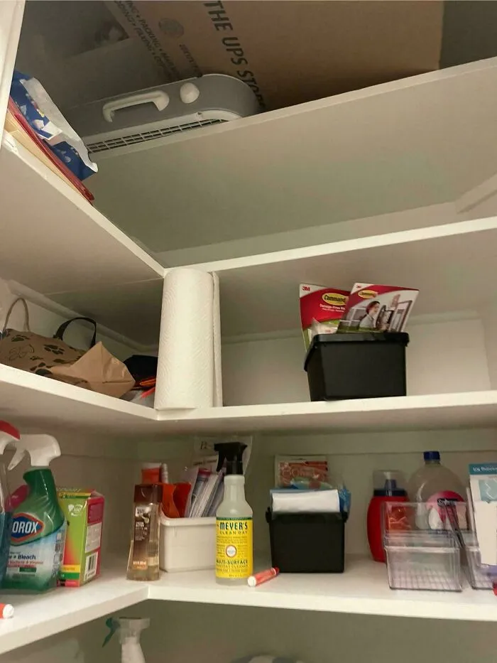 Polica s rôznymi čistiacimi prostriedkami a papierovými utierkami v domácnosti.