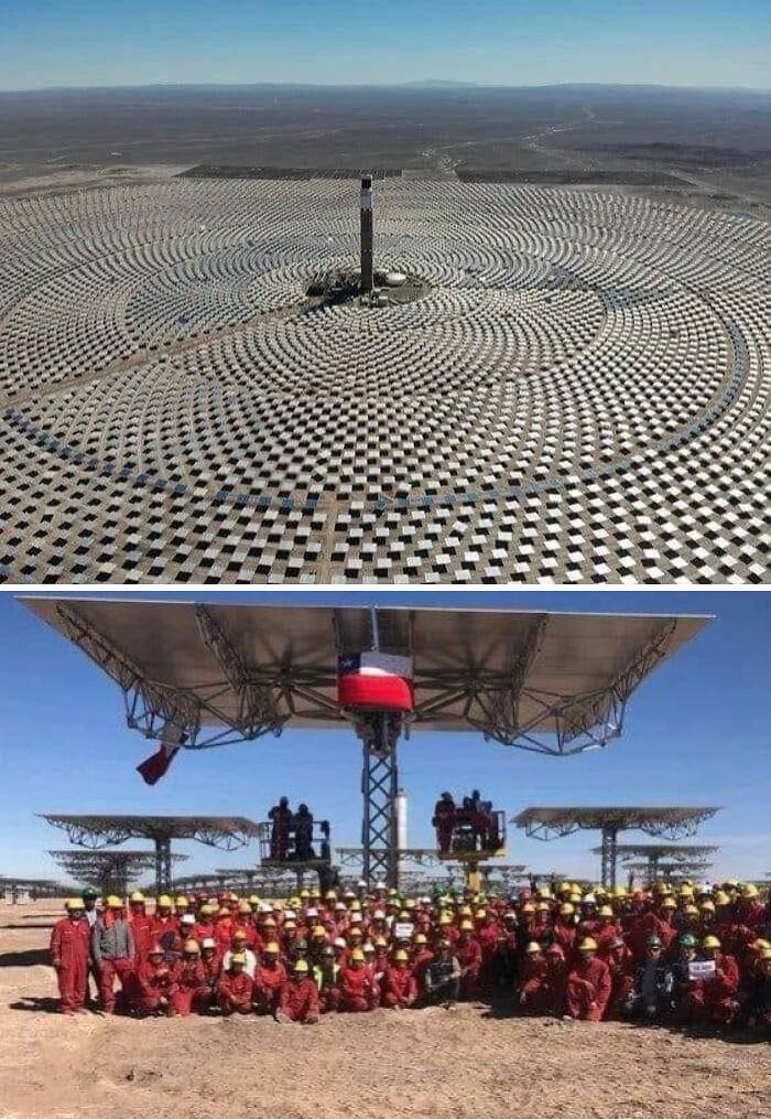 Solárne panely v púšti a tím pracovníkov na stavbe veľkej solárnej elektrárne.