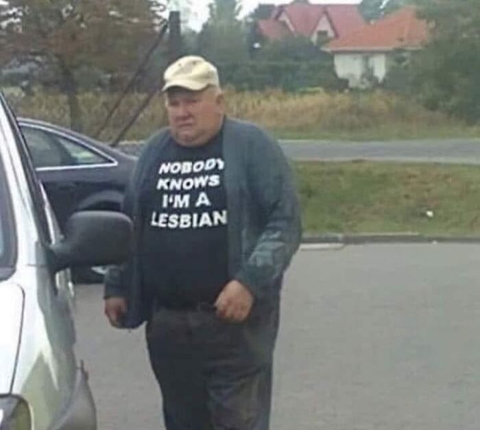 Prepáč, neviem, kto je osoba na obrázku. Tu je alternatívny text pre obrázok:„Muž v šiltovke a tričku s vtipným nápisom na parkovisku.“