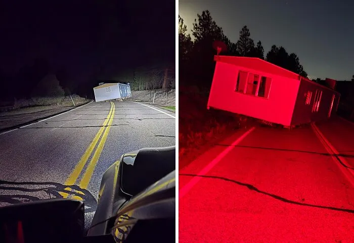 Dom na ceste blokuje premávku za tmy, osvetlený svetlami vozidla na prázdnej ceste.