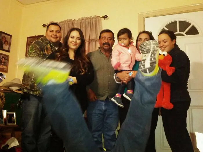 Ľudia pózujú na rodinnej fotografii s rozpačitými nohami pred objektívom.