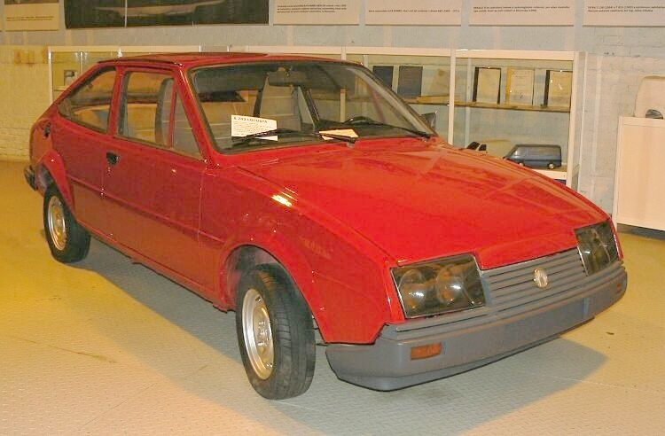 Červené retro auto vo výstavnej hale, zobrazené z predného uhla.