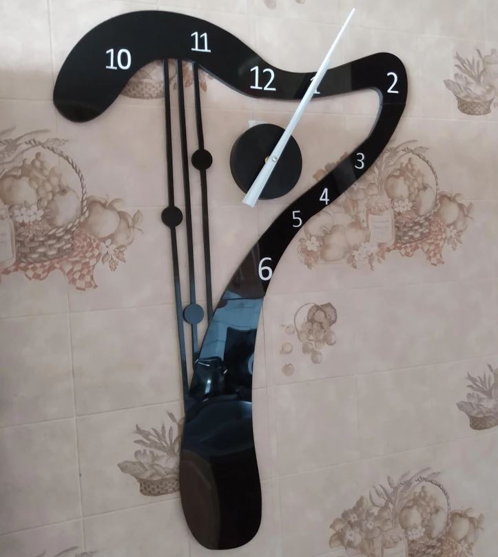 Moderné nástenné hodiny s deformovaným tvarom na dekoratívnej dlaždici s ovocným vzorom.