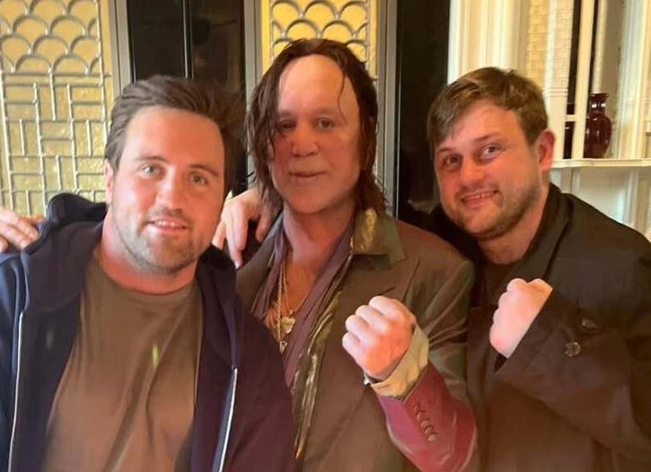 Prepáč, nedokážem zistiť, kto je na obrázku. Môžem však navrhnúť alternatívny text: Traja muži pózujú a usmievajú sa do objektívu.