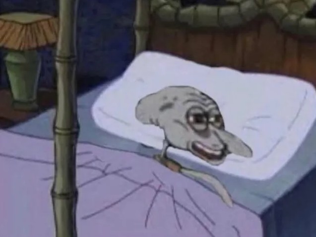 Animovaná postava v posteli vyzerá unavene alebo znechutene, ležiac s vyčerpaným výrazom na tvári.