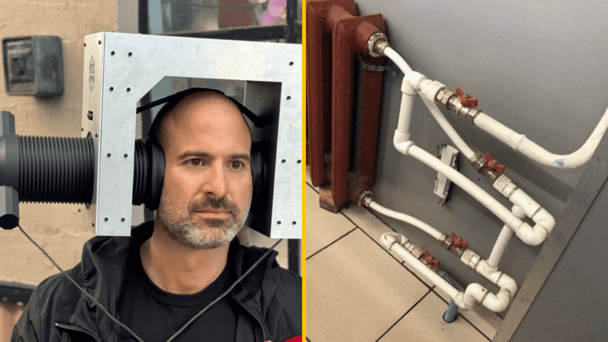 Osoba s veľkým zariadením na hlave vedľa zamotaných potrubí s ventilmi na stene.