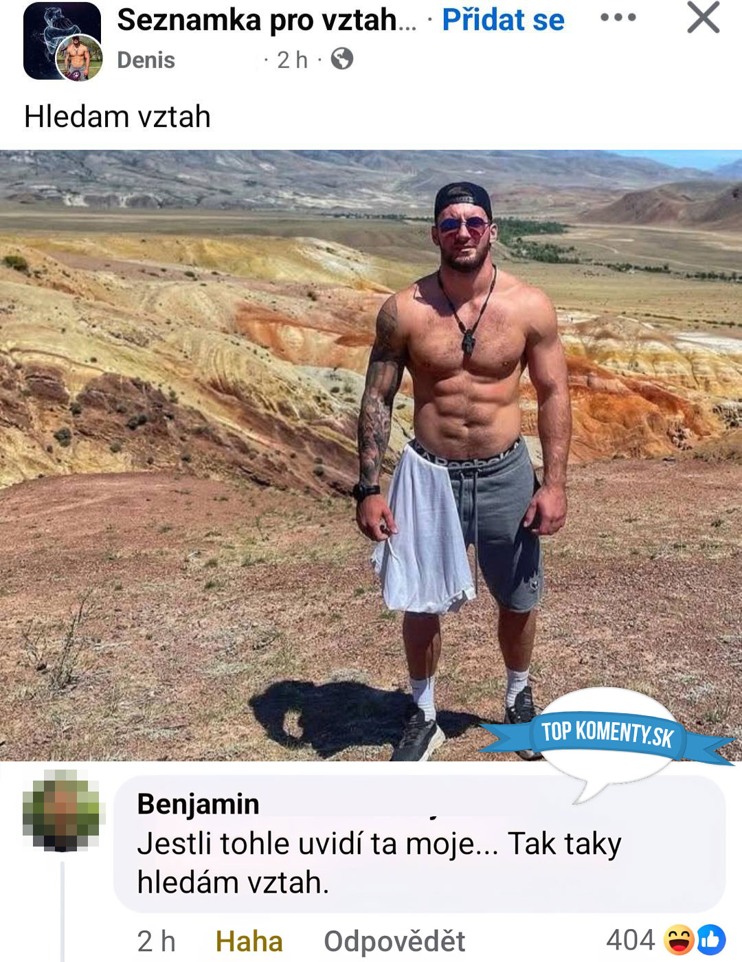 Muž bez trička stojí na púšti, v pozadí farebné kopce. Výrazné slnečné okuliare a čiapka. Hľadá vzťah.