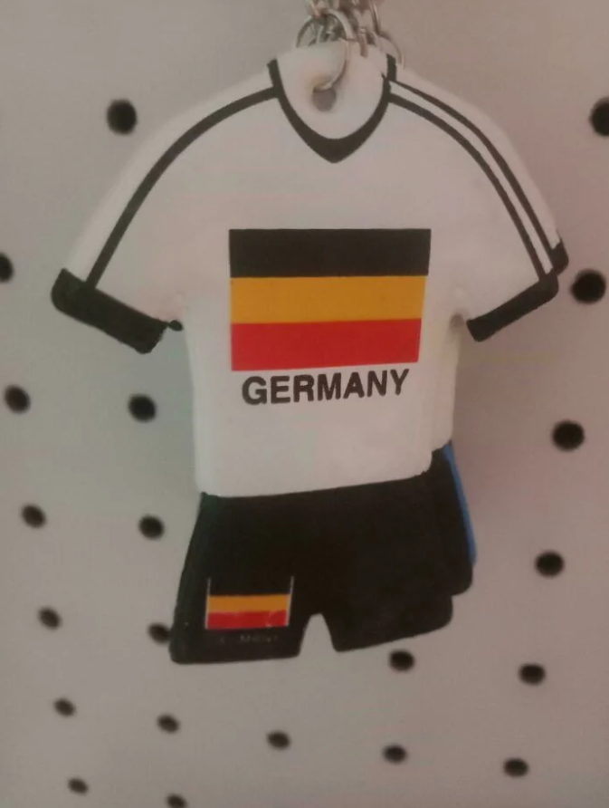 Miniatúrny nemecký futbalový dres s vlajkou Nemecka predávaný ako suvenír.