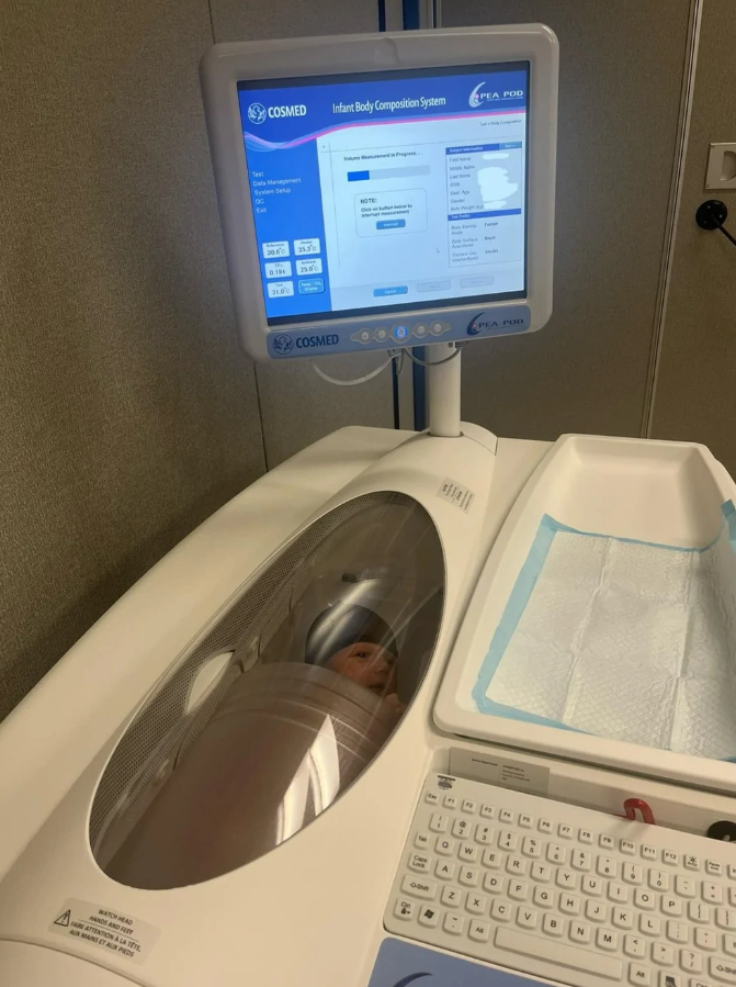 Bábätko v prístroji na meranie telesnej kompozície, monitor zobrazuje údaje.