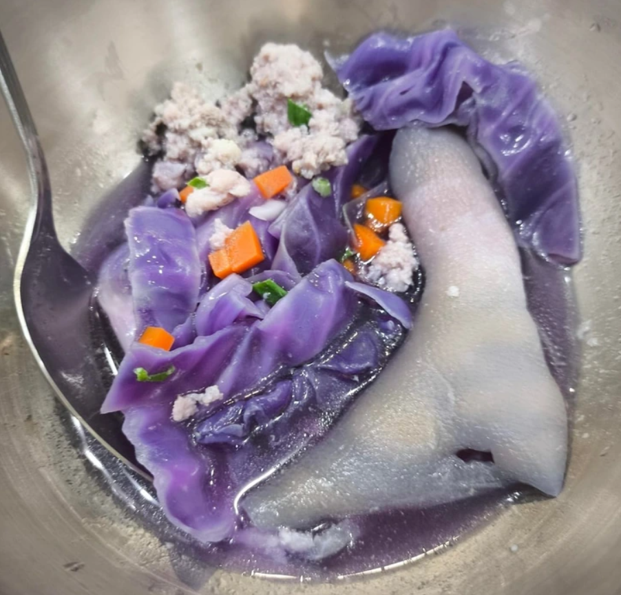 Fialová kapustová polievka s mrkvou a mletým mäsom v kovovej miske, lyžica vľavo.